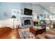 Inviting living room with stone fireplace, TV, hardwood floors, and a neutral-toned rug at 2115 W Pipkin Rd, Lakeland, FL 33811