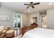 Bright main bedroom with wood flooring, ceiling fan, and access to the ensuite bathroom at 2115 W Pipkin Rd, Lakeland, FL 33811