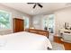 Bright main bedroom with wood flooring, ceiling fan, and access to the sewing room at 2115 W Pipkin Rd, Lakeland, FL 33811