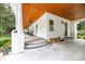 Expansive porch with herringbone brick floors, wood ceiling, and white pillars creates a perfect outdoor space at 2115 W Pipkin Rd, Lakeland, FL 33811