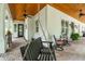 Inviting outdoor porch with a stained wood ceiling, herringbone pattern brick floors, and a black porch swing at 2115 W Pipkin Rd, Lakeland, FL 33811