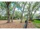 Spacious yard view with mature trees, a fence, and a glimpse of the home at 2115 W Pipkin Rd, Lakeland, FL 33811