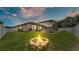 Picture of a backyard with a screened patio, green lawn, and stone fire pit at 2277 Bella Luna Cir, Lakeland, FL 33810