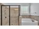 Stylish bathroom featuring a soaking tub, walk-in shower with sleek glass, and tiled walls at 2277 Bella Luna Cir, Lakeland, FL 33810