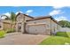 Beautiful single-Gathering home featuring a paver driveway, tile roof, and stone accents at 2277 Bella Luna Cir, Lakeland, FL 33810