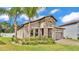 Lush landscaping surrounds this attractive single-Gathering home with a tile roof and stone accents at 2277 Bella Luna Cir, Lakeland, FL 33810