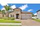 Charming home featuring a stone facade, clay tile roof, and a well-manicured lawn at 2277 Bella Luna Cir, Lakeland, FL 33810