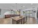 Open kitchen and living area with granite island, modern lighting and large brown sectional at 2277 Bella Luna Cir, Lakeland, FL 33810