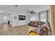 Spacious living room featuring tile floors, a ceiling fan, a TV, and a plush leather sofa at 2277 Bella Luna Cir, Lakeland, FL 33810