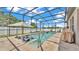 Inviting screened-in pool area with a lounge chair, umbrella, spa, and beautiful pavers at 2277 Bella Luna Cir, Lakeland, FL 33810