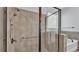 Modern walk-in shower with neutral tiles, a rainfall showerhead, and sleek glass enclosure at 2277 Bella Luna Cir, Lakeland, FL 33810