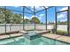 An elegant tiled spa within a screened enclosure offers a relaxing retreat with clear blue water at 2277 Bella Luna Cir, Lakeland, FL 33810