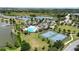 A high-angle view of community amenities including a pool, clubhouse, tennis courts, and a serene lake at 2468 Winnipeg Dr, Lakeland, FL 33805