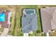 Aerial view of property with screened-in pool, well-manicured lawn, and gray roof at 2468 Winnipeg Dr, Lakeland, FL 33805