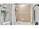 Bathtub with shower featuring decorative tile surround, shower head, soap and shampoo accessories at 2468 Winnipeg Dr, Lakeland, FL 33805
