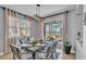 Dining room with modern light fixture, seating for six, and sliding glass doors leading to screened-in patio with lake view at 2468 Winnipeg Dr, Lakeland, FL 33805