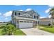 View of a home with a large garage, beautiful front lawn with plants and proximity to a lake at 2468 Winnipeg Dr, Lakeland, FL 33805