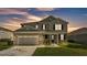 Charming exterior view of home featuring a two-car garage, well-maintained lawn, and a welcoming front porch at 2468 Winnipeg Dr, Lakeland, FL 33805