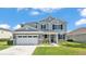 Daytime view of this two-story home's front featuring a large two-car garage, porch, and manicured lawn at 2468 Winnipeg Dr, Lakeland, FL 33805