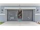 View of the home's two car garage behind a sliding screen with work bench and plenty of storage at 2468 Winnipeg Dr, Lakeland, FL 33805