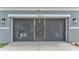 View of the home's two car garage behind a sliding screen with work bench and plenty of storage at 2468 Winnipeg Dr, Lakeland, FL 33805