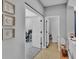 Hallway with three decorative flower pictures on the wall leading to an office and half bathroom at 2468 Winnipeg Dr, Lakeland, FL 33805