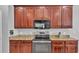 Kitchen with granite countertops, dark cabinets, and stainless steel appliances, including a gas range at 2468 Winnipeg Dr, Lakeland, FL 33805