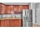 Kitchen featuring wood cabinets, granite countertops, stainless steel refrigerator, and a wine rack at 2468 Winnipeg Dr, Lakeland, FL 33805