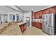 Open kitchen with granite counters, dark cabinets, stainless appliances and connection to the living area at 2468 Winnipeg Dr, Lakeland, FL 33805