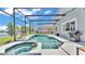 Beautiful screened pool and spa area featuring a grill, outdoor seating, and tranquil views of the lake at 2468 Winnipeg Dr, Lakeland, FL 33805