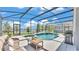 Inviting screened pool and spa with ample patio space, grill, and a serene lake view at 2468 Winnipeg Dr, Lakeland, FL 33805