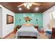 Cozy bedroom showcasing accent wall with decor, ceiling fan, and wood floors at 2520 Avenue C Sw, Winter Haven, FL 33880