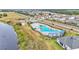 Aerial view of the community pool, featuring a uniquely shaped pool, sunshades, and lounge seating at 2611 San Marco Way, Winter Haven, FL 33884