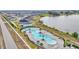 Spacious community pool featuring a unique shape, mature palm trees, ample lounge chairs, and shady cabanas at 2611 San Marco Way, Winter Haven, FL 33884
