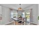 Contemporary dining room with natural light from windows and sliding glass doors provides serene views of outdoor greenery at 2611 San Marco Way, Winter Haven, FL 33884