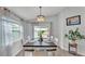 Bright dining room featuring a modern chandelier, large window, and sliding glass doors to the outdoor living area at 2611 San Marco Way, Winter Haven, FL 33884