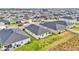 Aerial view of modern homes with dark gray roofs in a planned community with green spaces at 2611 San Marco Way, Winter Haven, FL 33884