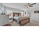 Cozy main bedroom with a rustic wood bed frame, ceiling fan, and natural light from the windows at 2611 San Marco Way, Winter Haven, FL 33884
