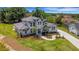 An aerial view shows the home's facade, driveway, lawn, landscaping, and surrounding area at 2645 Delphi Hills Ct, Lakeland, FL 33812