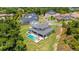 An aerial shot shows the property's swimming pool, landscaping, facade, lawn, and mature trees at 2645 Delphi Hills Ct, Lakeland, FL 33812