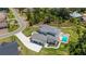 Stunning aerial view of the modern home featuring a pool, lush landscaping, and a spacious driveway at 2645 Delphi Hills Ct, Lakeland, FL 33812