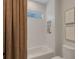 Clean and modern bath area featuring decorative tile work in shower, linen curtain, and a toilet at 2645 Delphi Hills Ct, Lakeland, FL 33812
