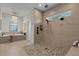 Ensuite bathroom boasting a shower, tub, and chandelier lighting with natural light from an adjacent window at 2645 Delphi Hills Ct, Lakeland, FL 33812