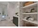 Stylish pool bathroom features custom wallpaper, floating vanity, open shelving, and easy access to the backyard at 2645 Delphi Hills Ct, Lakeland, FL 33812
