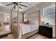 Well-lit bedroom featuring a four-poster bed, a ceiling fan and access to the ensuite bathroom at 2645 Delphi Hills Ct, Lakeland, FL 33812