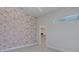 Stylish bedroom featuring decorative wallpaper and an adjacent closet entrance, blending aesthetics with practicality at 2645 Delphi Hills Ct, Lakeland, FL 33812