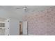 Inviting bedroom with decorative wallpaper and an entrance to a brightly lit bathroom, creating a stylish and functional space at 2645 Delphi Hills Ct, Lakeland, FL 33812