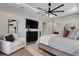 Modern bedroom featuring a canopy bed, TV, sitting chair, and access to an ensuite bath at 2645 Delphi Hills Ct, Lakeland, FL 33812