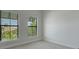 Neutral bedroom with carpet, windows, and view of a neighborhood building providing a serene and calming atmosphere at 2645 Delphi Hills Ct, Lakeland, FL 33812