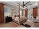 A modern bedroom features a canopy bed, a ceiling fan, and access to an outdoor balcony at 2645 Delphi Hills Ct, Lakeland, FL 33812